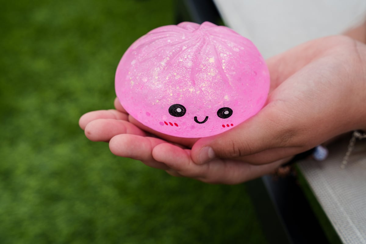 A child holding a pink glitter dumpling squishy toy